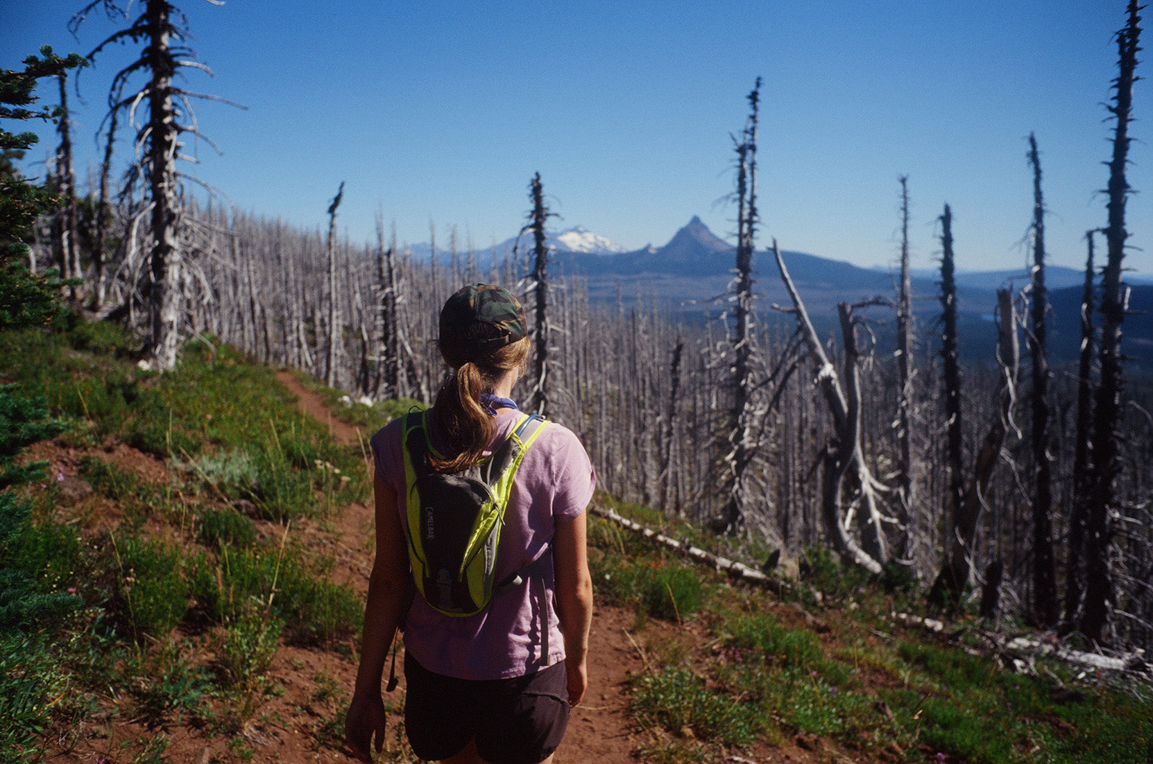 A hiker carries a small day pack backpack with a water bladder