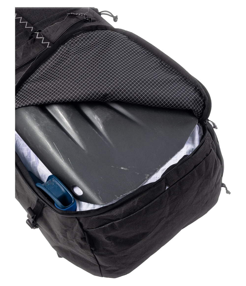 Raide SB 40L backcountry ski pack in Black with back panel access open, revealing molded composite insert with anti-bulge ribs, mesh breathable panel, and main compartment containing avalanche shovel blade and hydration reservoir