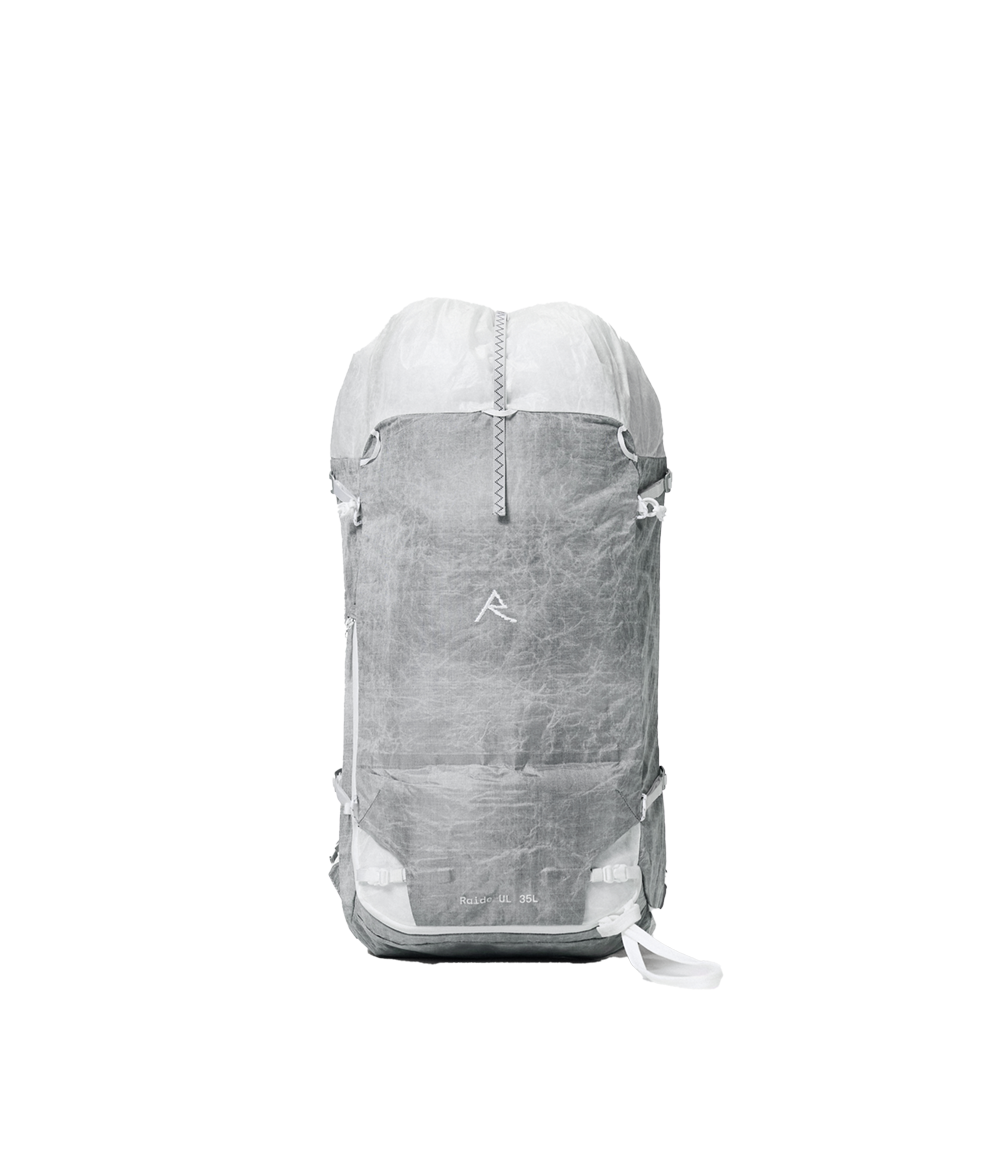 Raide UL 35L backcountry ski pack in light grey ALUULA fabric with rolltop closure, compression straps, and minimalist design featuring the brand's mountain logo