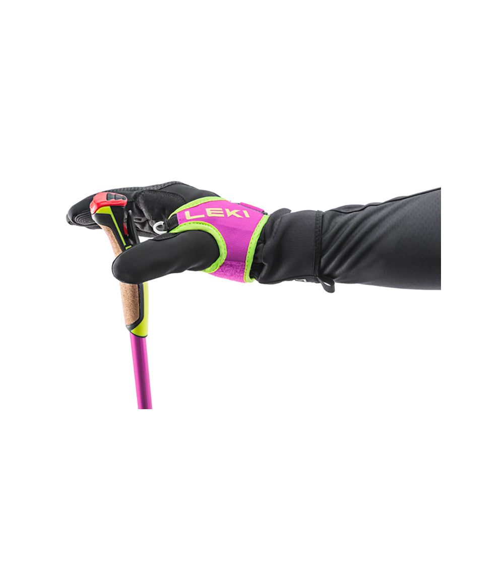 Leki PRC 750 cross-country ski pole in pink and yellow with Nordic Shark grip, Shark Frame Strap with quick-release button, and cork handle held by gloved hand demonstrating strap system.